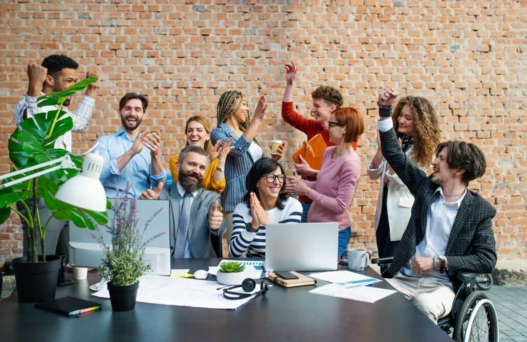 Entrepreneurs working on project indoors in office, celebrating successful contract.